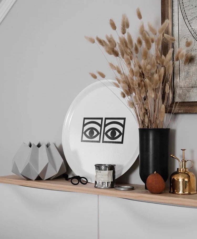 Vit rund bricka med Olee Eksells design Ögon cacao