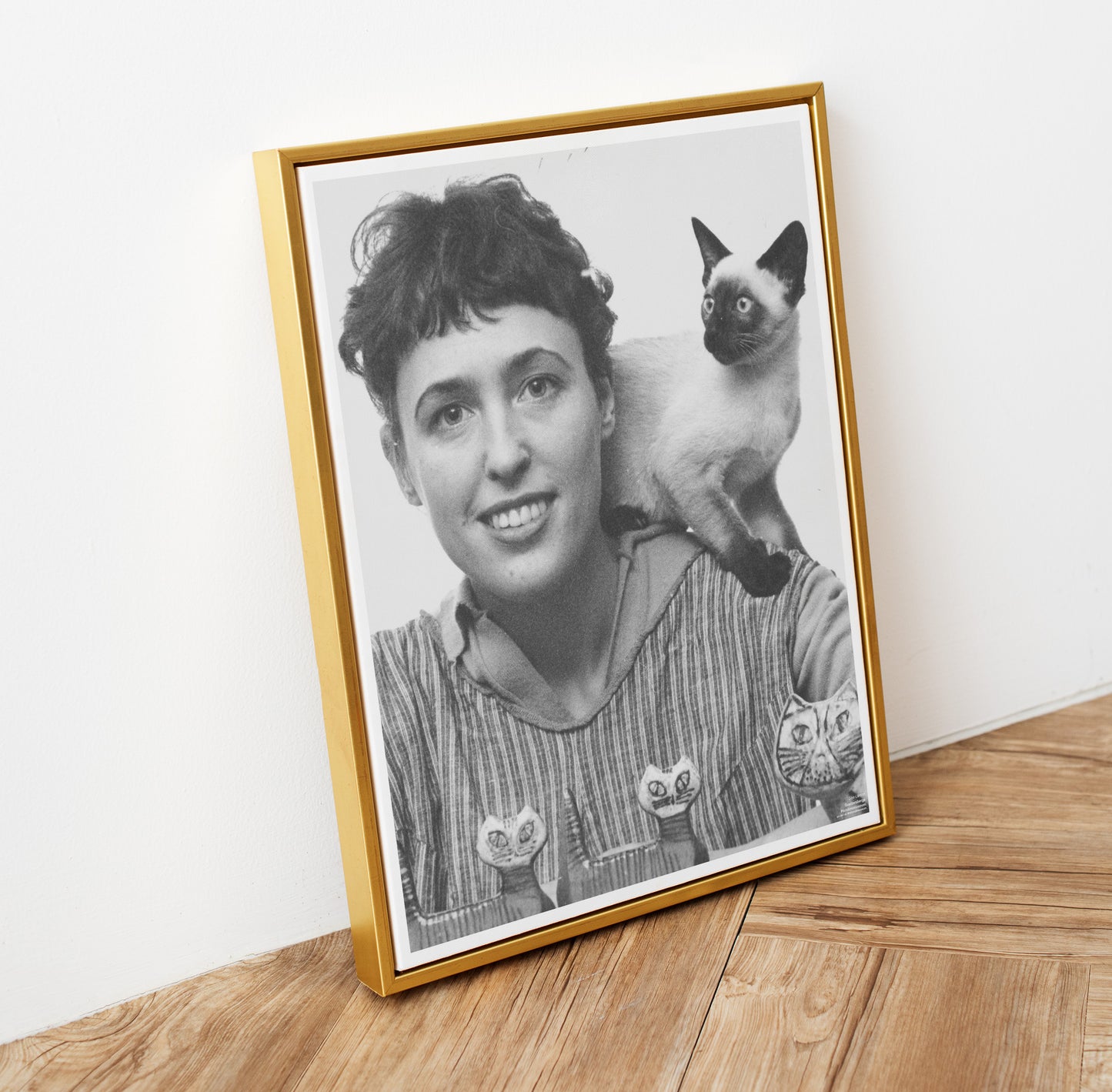 Svartvitt poster med lisa larson och hennes katt i guldfärgad ram
