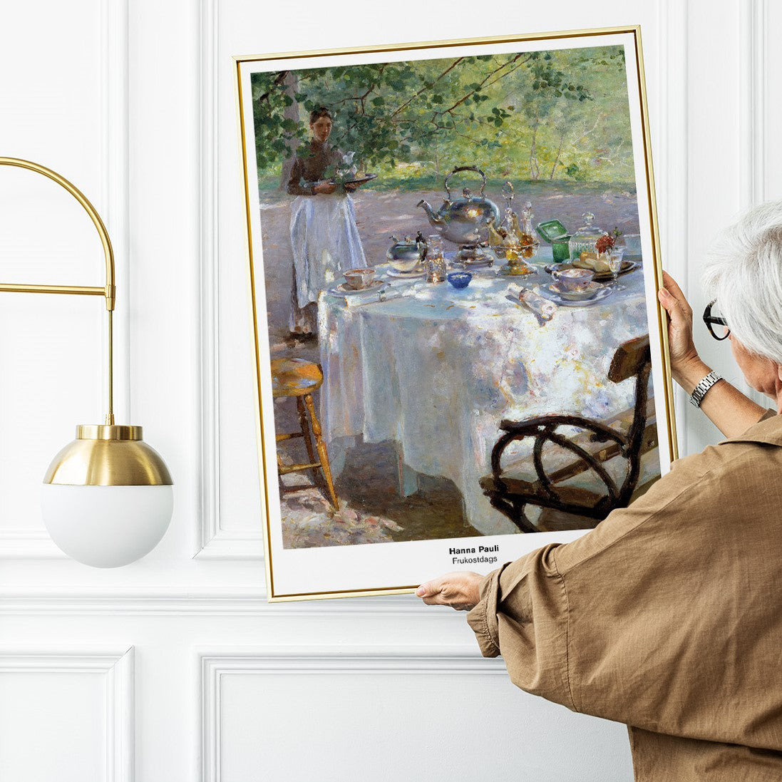 kvinna som håller upp poster med Frukostdags i guldfärgad ram