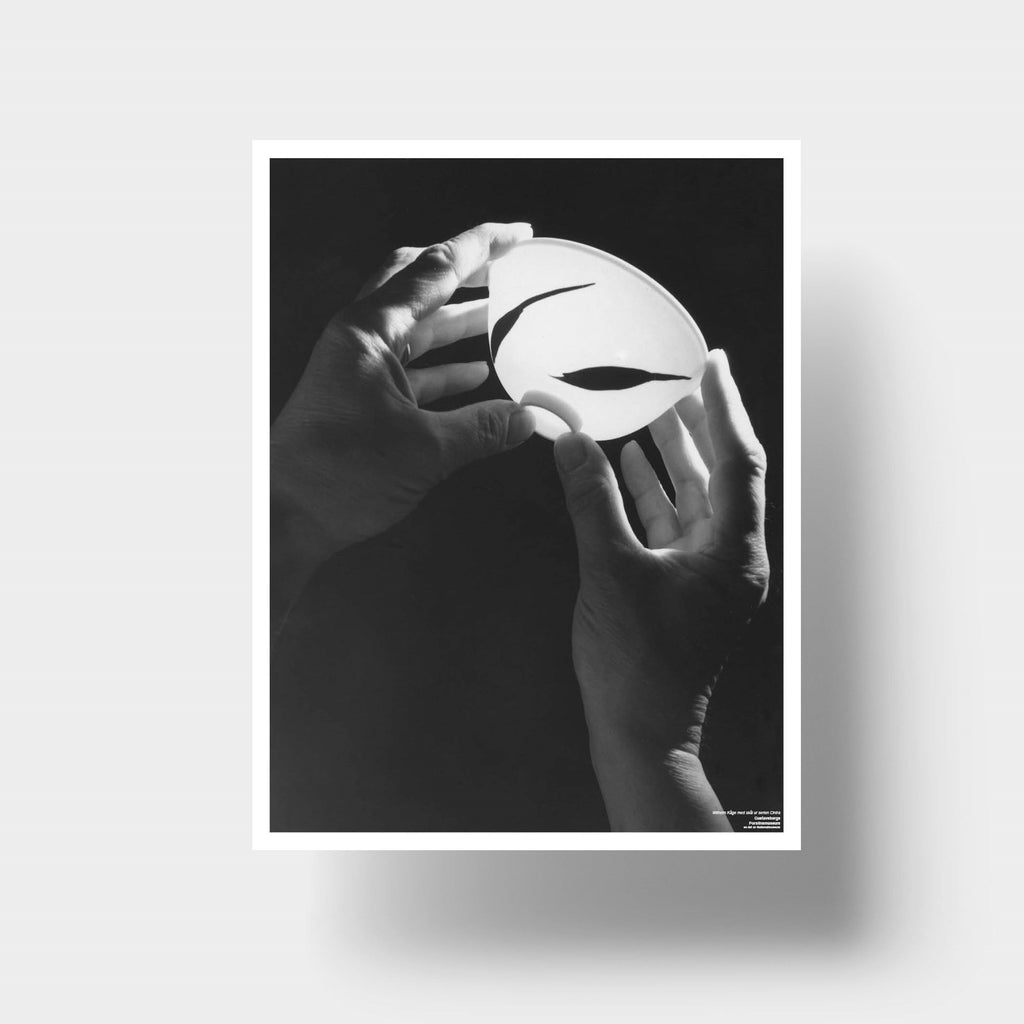Svartvit poster med fotografi där Wilhelm Kåge håller upp en skål ur serien Cintra