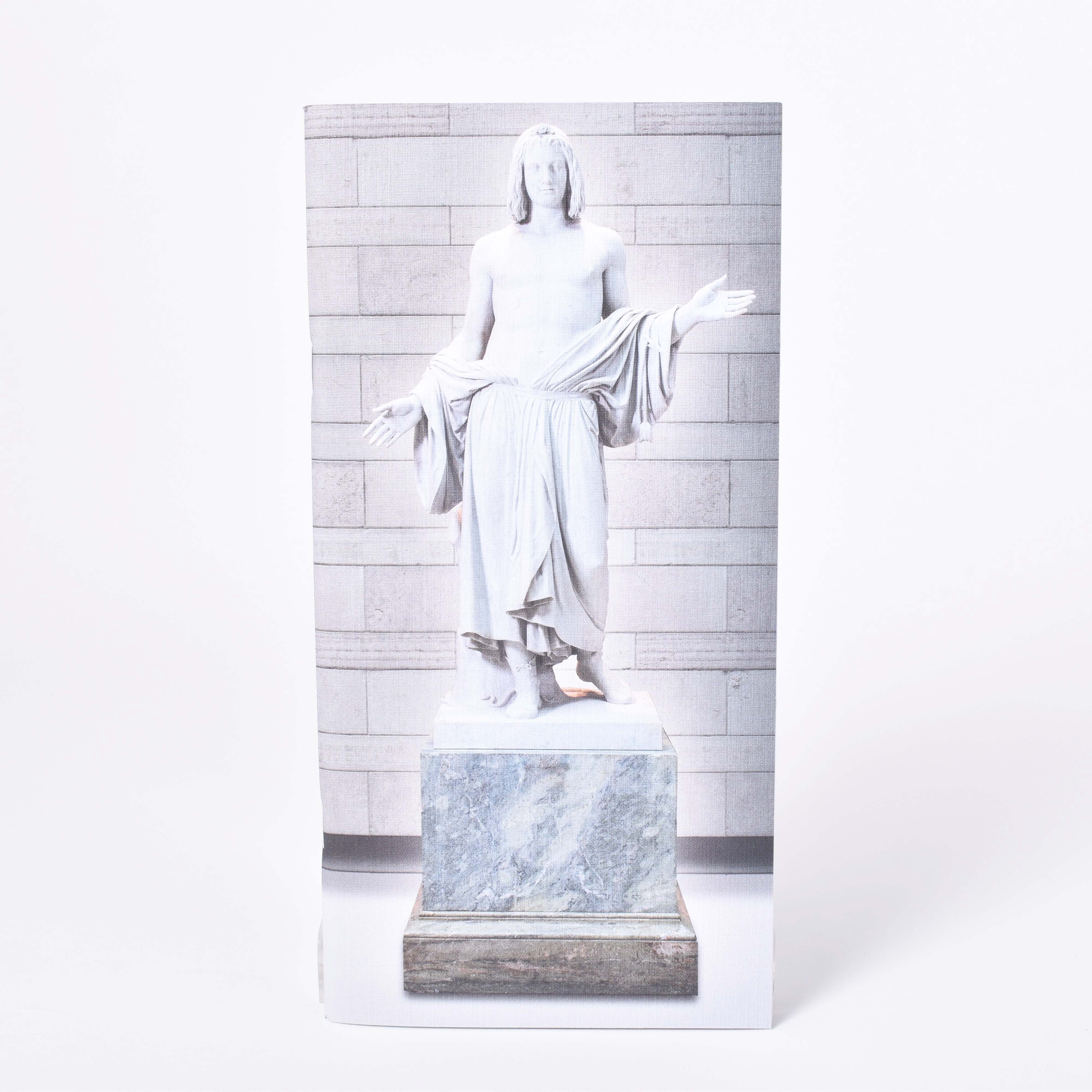 Långsmal anteckningshäfte med omslagsmotiv av Bengt Erland Fogelbergs skulptur Balder