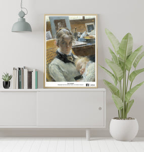 poster med Carl Larssons målning Ateljéidyll i träram på grått skåp