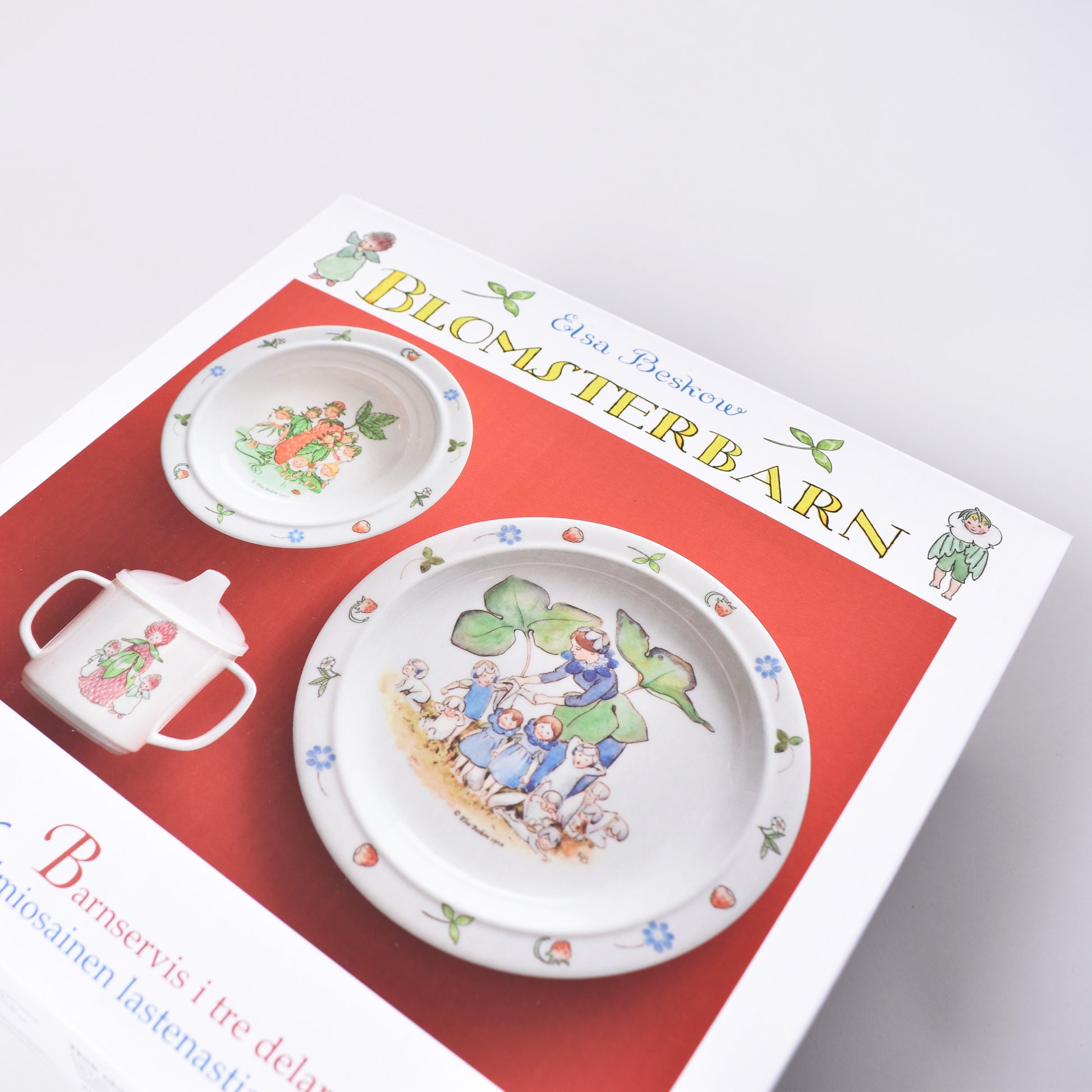 Servis med platt och djup tallrik och pipmugg och motiv från Elsa Beskows saga Blomsterbarn