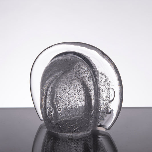 Ljuslykta till bordet av klart glas med små bubblor i