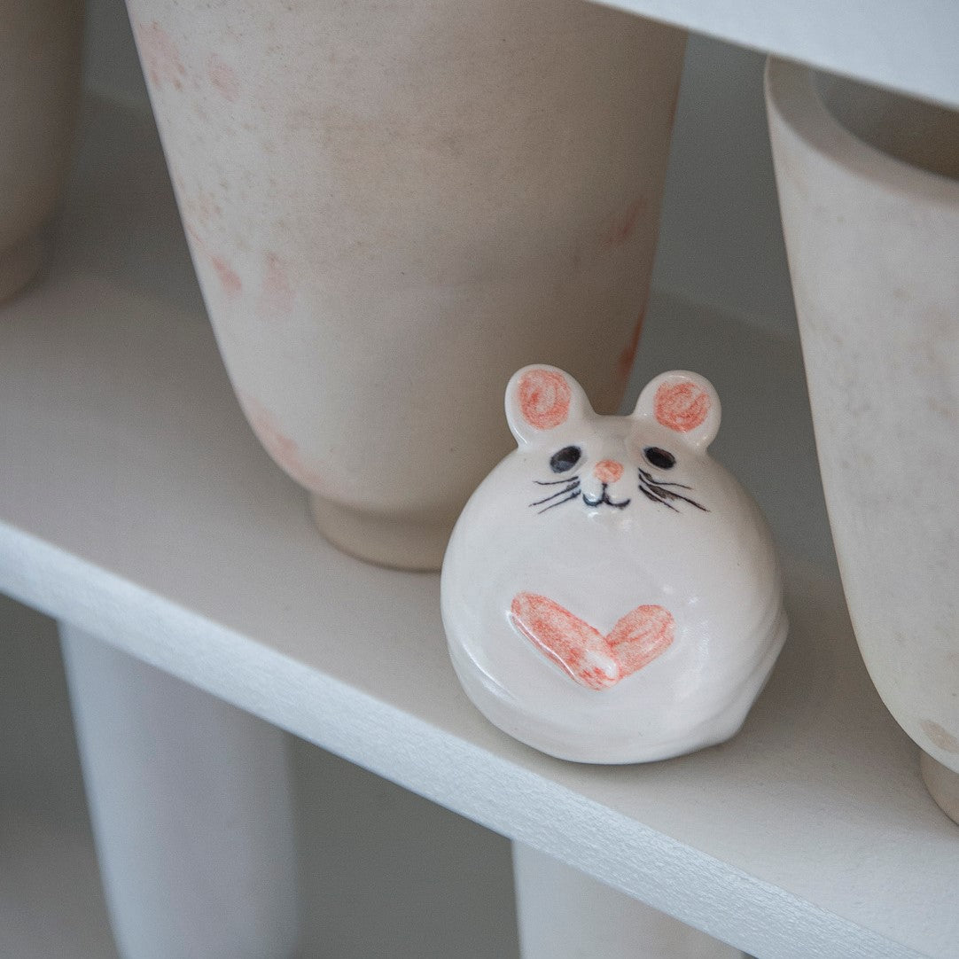 vit och rosa kermikmus av lisa larson bland keramikkrukor på gustavsbergs porslinsmuseum