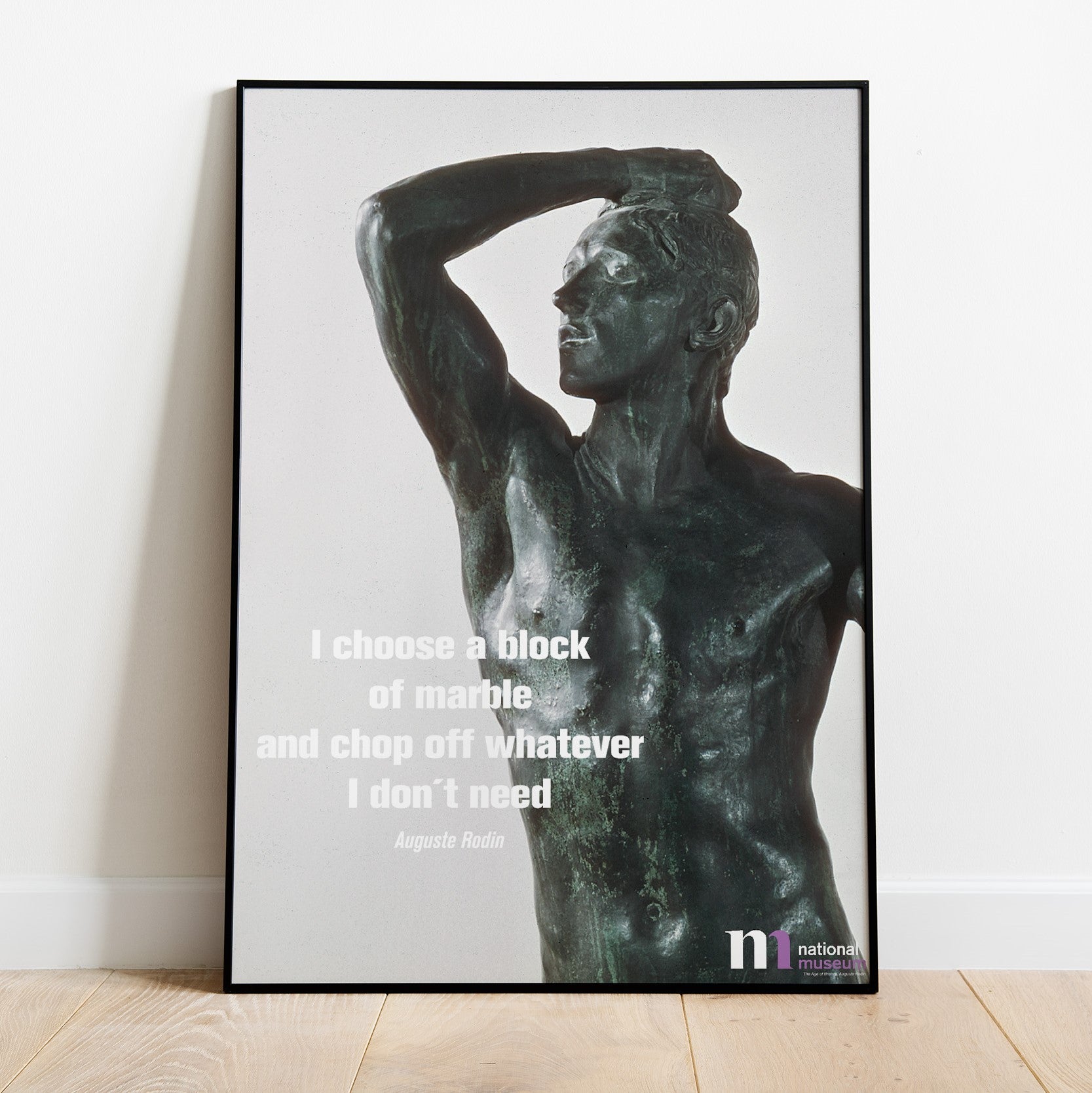 Poster med Rodins skulptur Bronsåldern från NAtionalmuseum i svart ram lutad mot en vägg