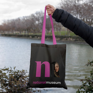 Svart shoppingkasse med rosa handtag och nationalmuseums logga med damen i slöjan